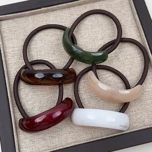 Macro detail of high-elasticity hair ties with curved resin charms in five elegant colors