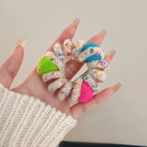 Close-up of colorful knitted spiral phone line hair tie with soft fuzzy texture