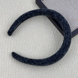 Detail of grey plush headband with coarse grain texture and white HAND MADE label