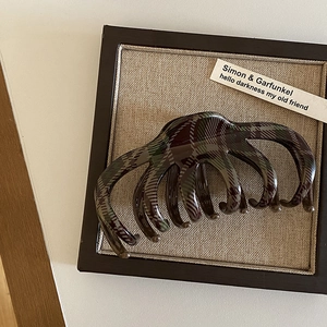 Dettaglio di un grande fermaglio per capelli con motivo scozzese rosso e verde retrò