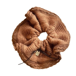 Knitted brown hair scrunchie with soft wool texture and elegant golden charm detail