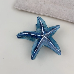 Close-up of starfish claw clip in blue gradient acetate with white polka dots