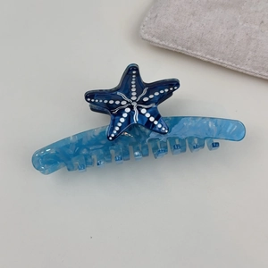 Detail view of blue starfish acetate hair claw clip with elegant marble texture finish