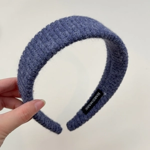Detailed close-up of dark blue knit headband showing fuzzy mohair texture and handmade label