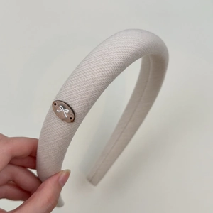Close-up of beige thickened sponge headband with twill fabric and bow ornament