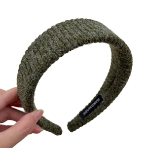 Deep green knitted striped wide headband for women featuring a handmade label detail