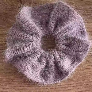 Macro d'un chouchou tricoté violet duveteux avec texture en fausse fourrure sur bois sombre