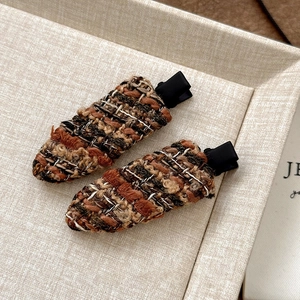 Close-up of vintage tweed fabric hair clips in brown and beige patterns for women
