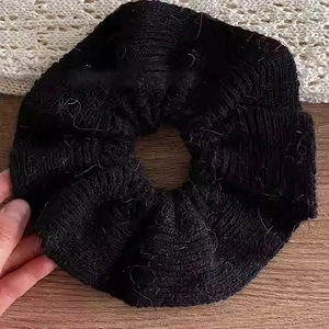 Vue macro d'un chouchou noir en maille épaisse avec une texture plissée et douce