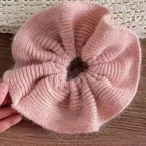 Gros plan d'un chouchou surdimensionné en tricot rose avec une texture douce en mohair