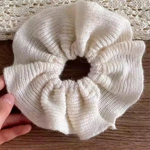 Détail de la texture en maille côtelée crème d'un chouchou surdimensionné et moelleux