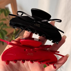 Black and red acetic acid hair claws with silk ribbon bows and gold lettering accents
