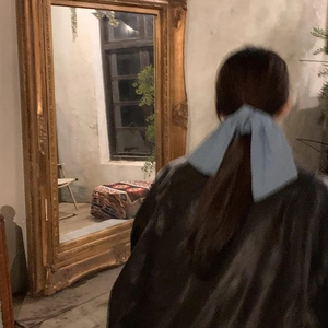 Vintage blue denim texture large bow scrunchie for women tied on a low ponytail