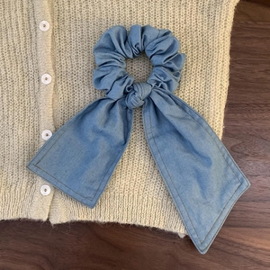 Retro denim blue scrunchie with long ribbon and yellow stitching on knitted cardigan