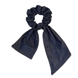 Deep blue denim scrunchie with long ribbons and contrast stitching on white background