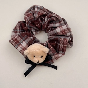 Dettaglio dell'elastico per capelli scozzese retrò con un simpatico orsetto di peluche