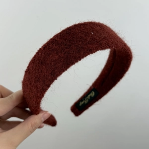 Détail d'un serre-tête en peluche bordeaux avec texture mohair et broderie dorée fine