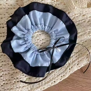 Detail of baby blue denim scrunchie with black ribbon bow and pearl teardrop accent