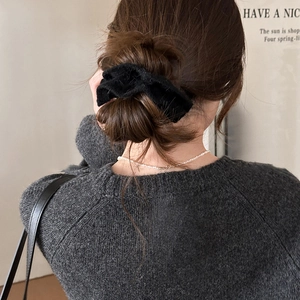 Gros nœud papillon en velours noir pour chignon, vu de dos sur un modèle avec pull doux
