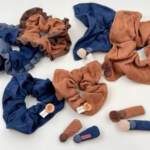 Stoff-Haargummis mit Holzknöpfen und Bommeln in Blau und Braun für Herbst-Winter-Accessoires