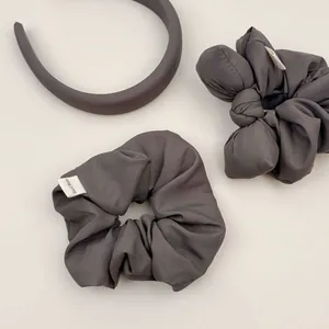Detailed view of dark grey handmade scrunchies and headband with silk-like soft texture