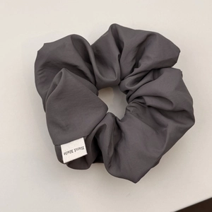 Detail of grey handmade scrunchie fabric texture and Hand Made textile label close-up