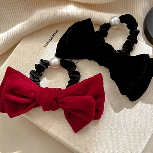 Eleganti elastici per capelli in velluto rosso e nero con perle su sfondo in maglia