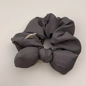 Close-up of charcoal gray bubble cotton scrunchie with handmade label detail
