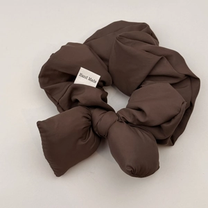 Detail of coffee brown bubble fabric scrunchie with bow and Hand Made tag