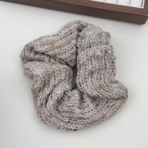 Détail d'un chouchou en maille douce avec texture laine grise et taches colorées d'hiver