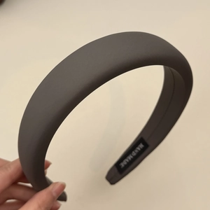Detail of dark grey padded headband with silk-like finish and handmade inner label