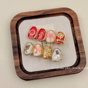 Detail of red floral hair clips with rose embossing and dried flower resin inserts