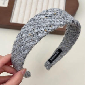 Détail du serre-tête tricoté gris avec texture en tweed vintage et étiquette faite main