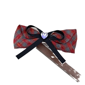 Barrette à nœud écossais rouge et gris avec strass en forme de cœur sur fond blanc