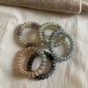 Four-piece gradient spiral hair coils in Morandi colors on soft neutral fabric background