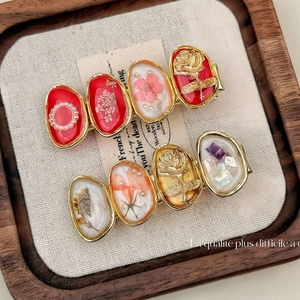 Elegant red resin flower hair clip with dried flowers and gold rose relief on wood tray