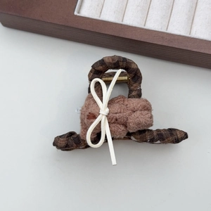 Close-up of leopard pattern hair claw clip with a cute plush brown bear and white bow