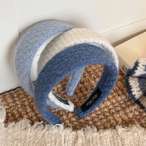 Three knitted diamond pattern wide headbands in light blue, off-white, and grey-blue colors