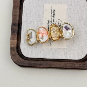 Detailed macro view of vintage hair clip with embedded dried flowers and golden roses