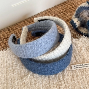 Three-piece set of knitted diamond pattern headbands in cream, light blue, and navy blue