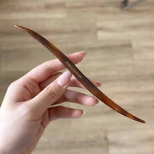 Dettaglio del fermaglio per capelli tartarugato fatto a mano con scritte dorate