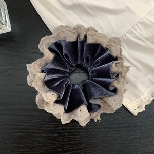 Detailed view of dark velvet hair scrunchie with grey lace floral embroidery edges