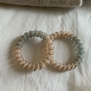 Detailed macro of two-tone spiral hair coils in grey-blue and beige resin material