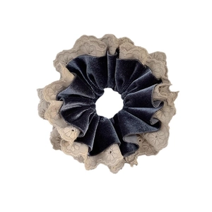 Elegant grey-blue velvet scrunchie with beige floral lace embroidery on white background