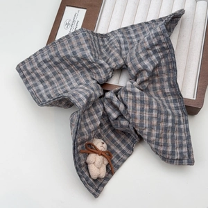Detail of taupe plaid scrunchie with 3D teddy bear and brown ribbon on wooden tray