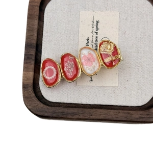 Vintage red flower hair clip with resin oval patterns and gold rose relief detail