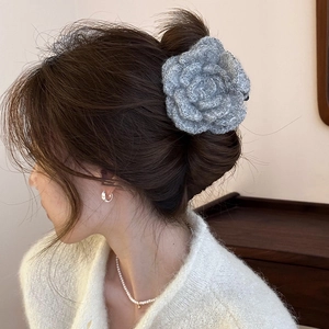 Elegant grey knitted rose hair claw clip for women shown on a model hair bun