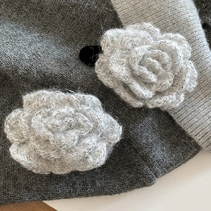 Close-up of white crochet rose hair clip with silver glitter thread and soft yarn texture