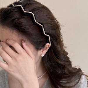 Elegant black velvet wavy headband with pearls shown on model in a side view