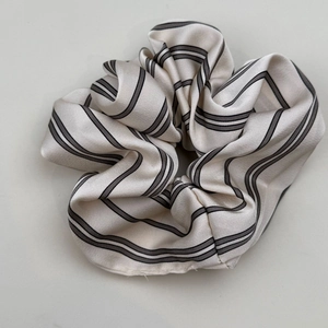 Detail of striped silk scrunchie with French retro pattern and pearl pendant texture